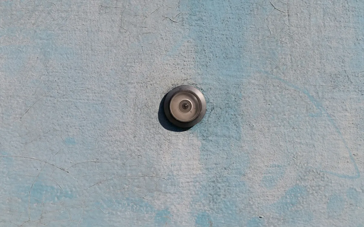 Olho mágico em uma porta clara.