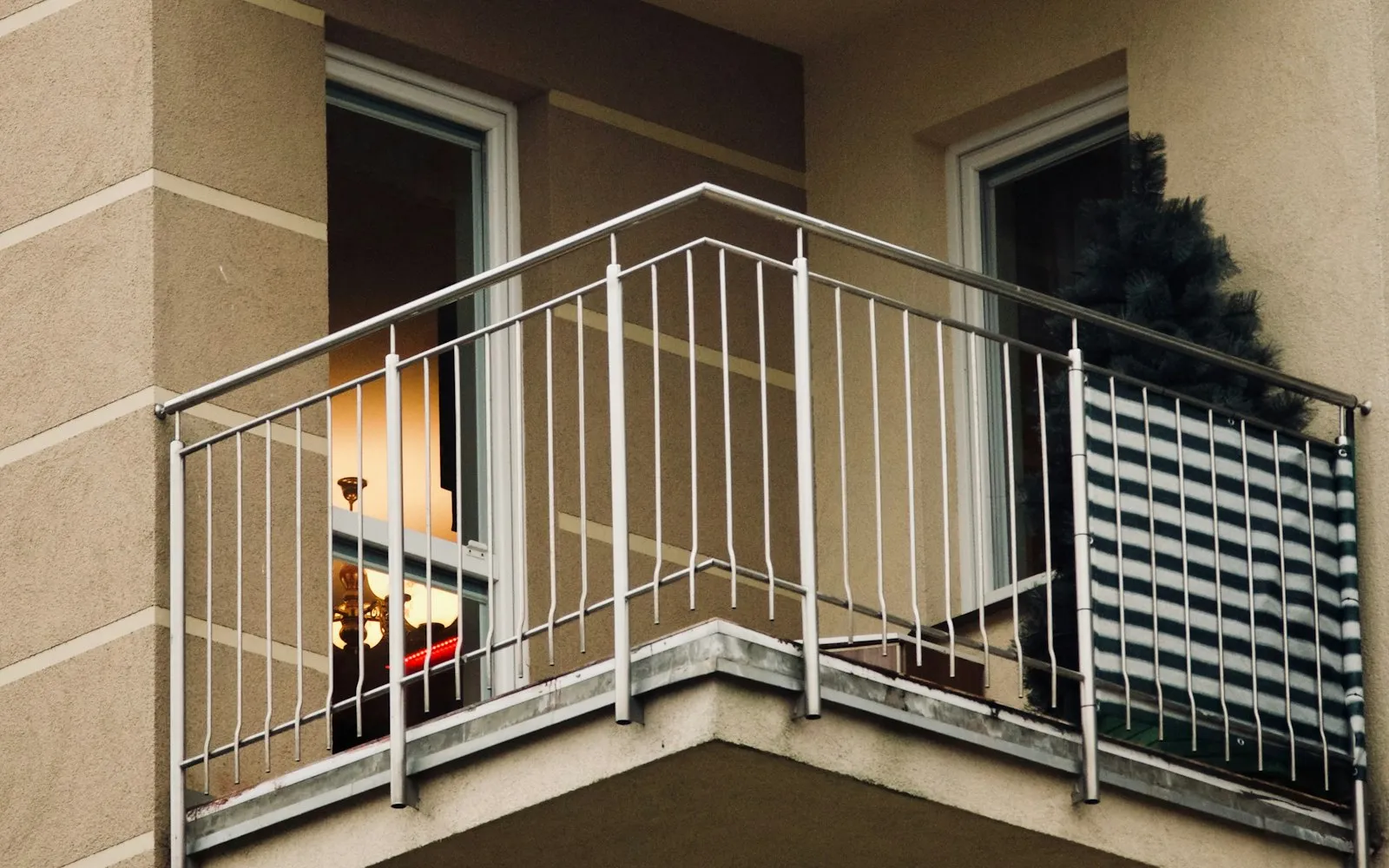 Varanda com grade metálica na fachada de um prédio residencial.
